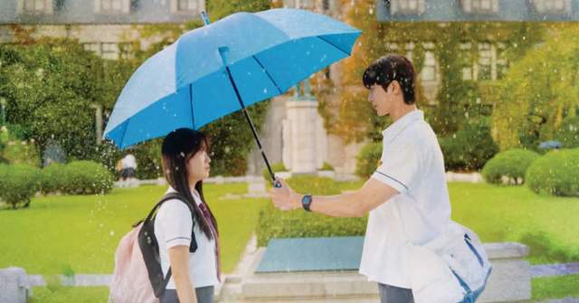 Byeon Woo Seok and Kim Hye Yoon, stars of Korean drama "Lovely Runner," under a blue umbrella are depicted in a poster.